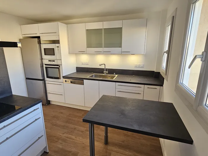 Cuisine blanche avec bar et plan de travail effet béton