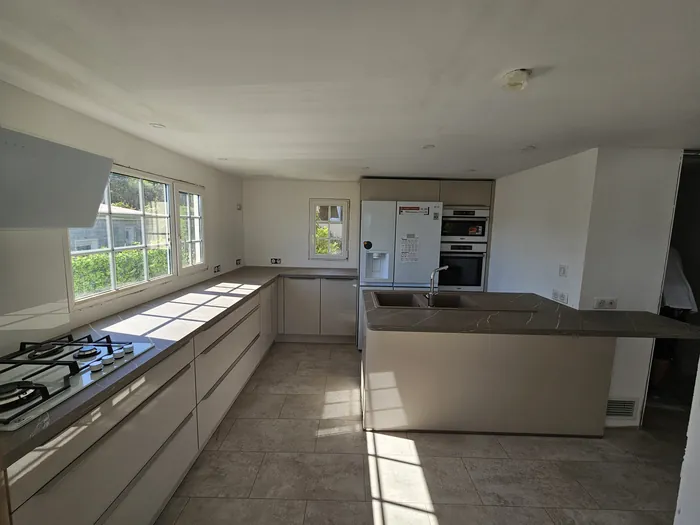 Grande cuisine taupe laquée avec îlot effet marbre à Fréjus